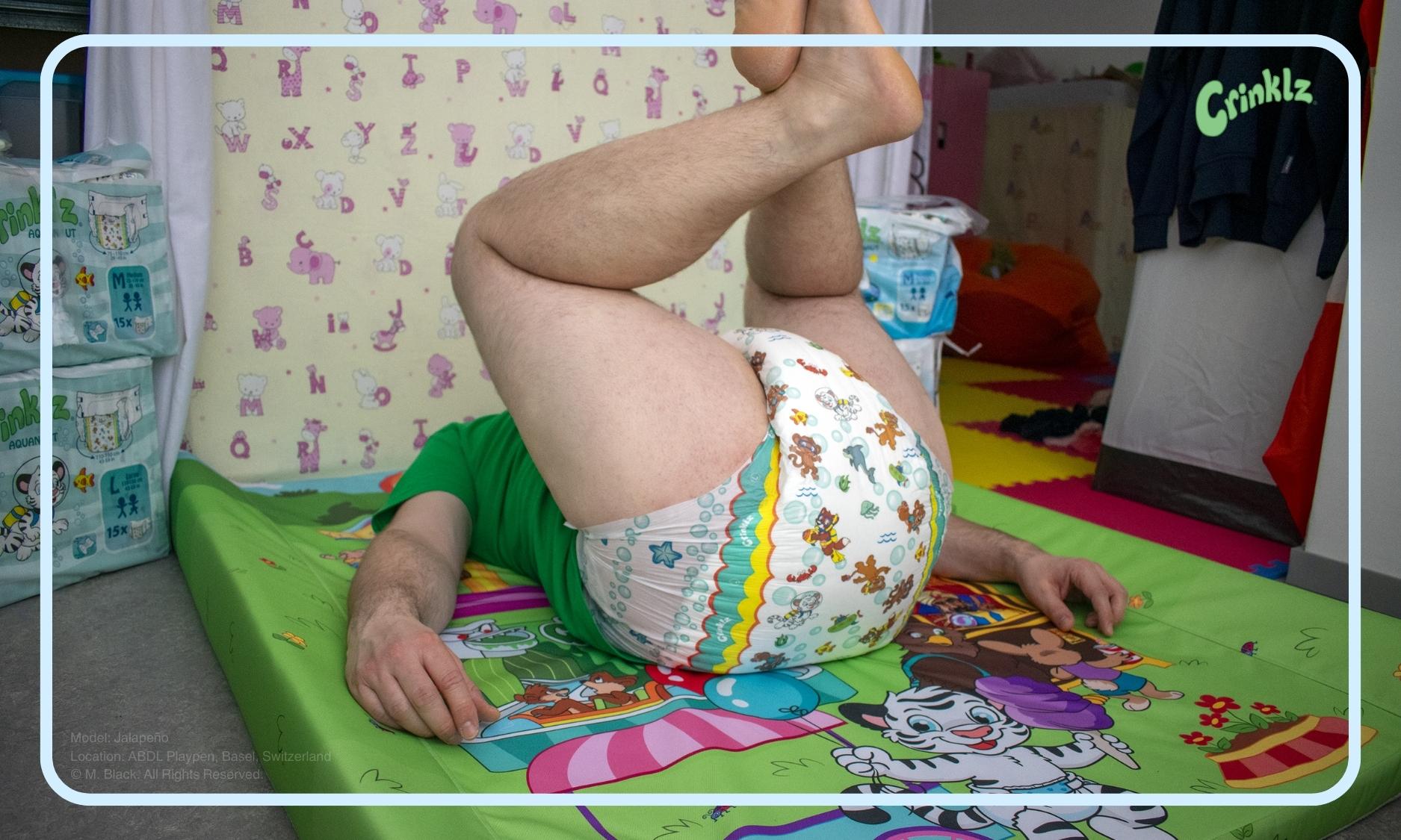 Model wearing Crinklz Aquanaut print diapers while on an adult changing pad at ABDL Playpen in Basel, Switzerland.