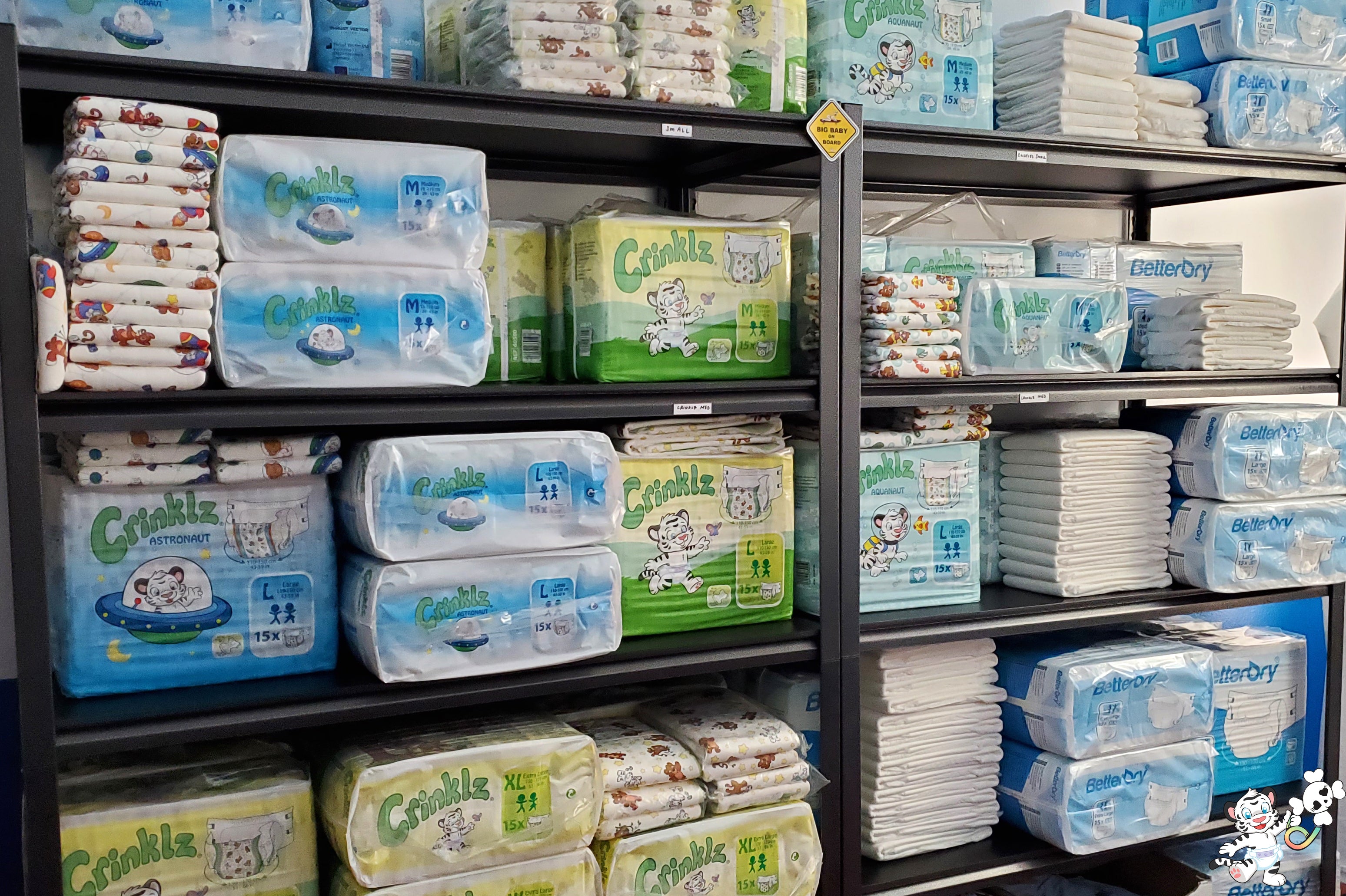 Stacks of Crinklz adult diapers. Shown are Astronaut, Original, and Aquanaut prints. Also shown are BetterDry adult diapers.