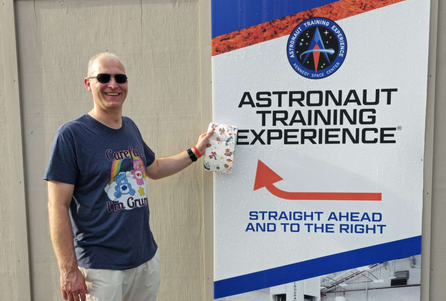 JP holding a Crinklz Astronaut print adult diaper in front of the Astronaut Training Experience sign at the Kennedy Space Center