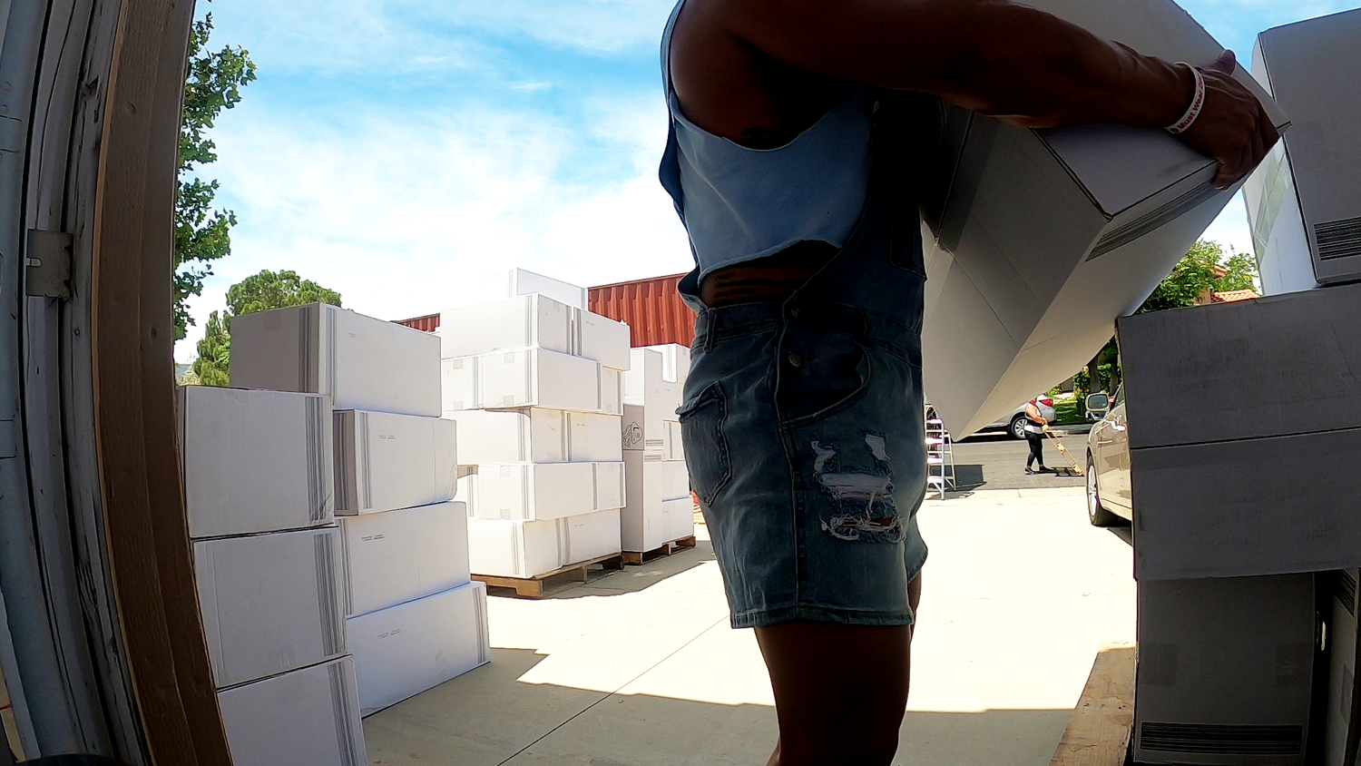 A helper unloads a Thrust Vector shipping container and stacks Crinklz adult diaper cases.
